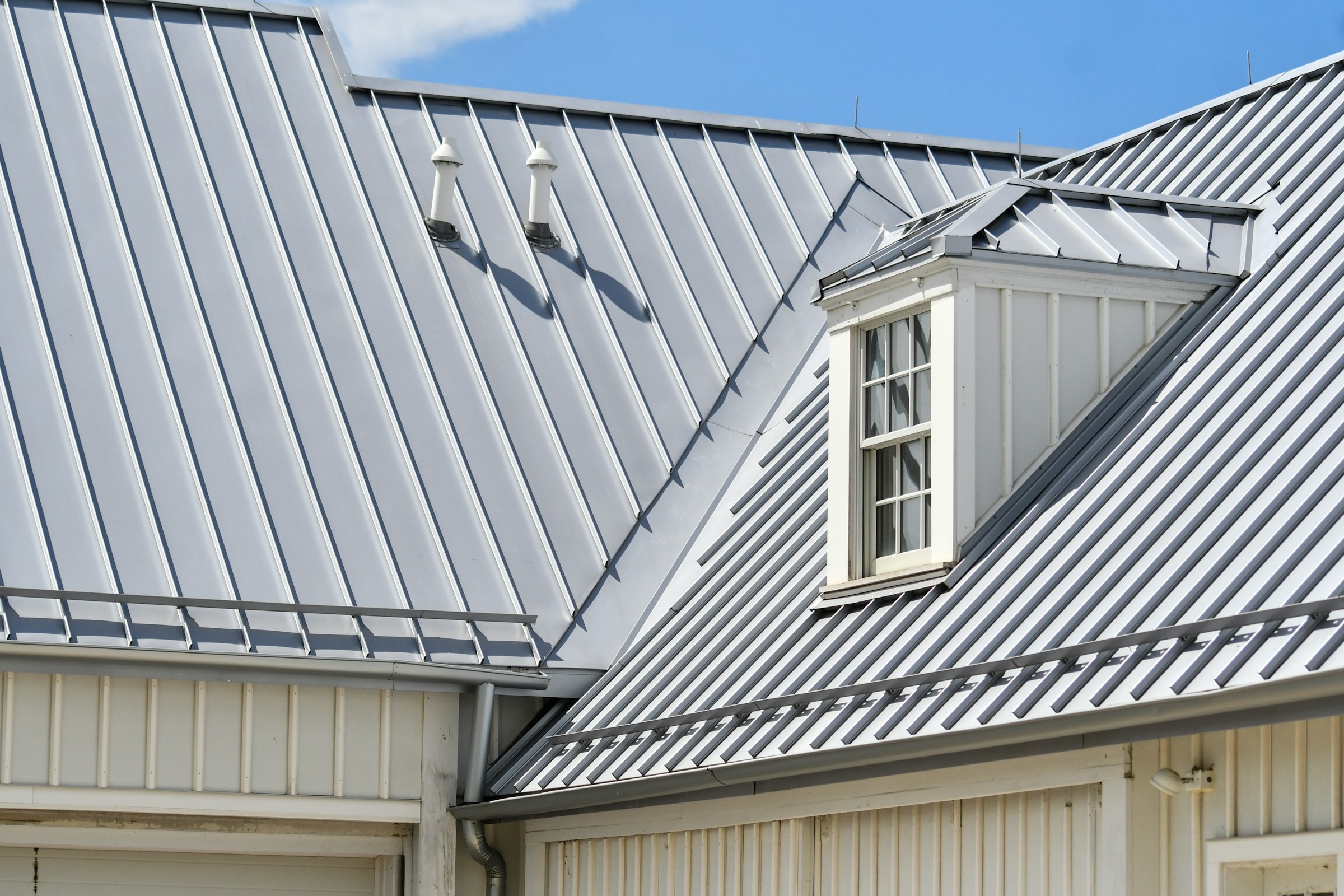 Grey metal roof on a home with a dormer window