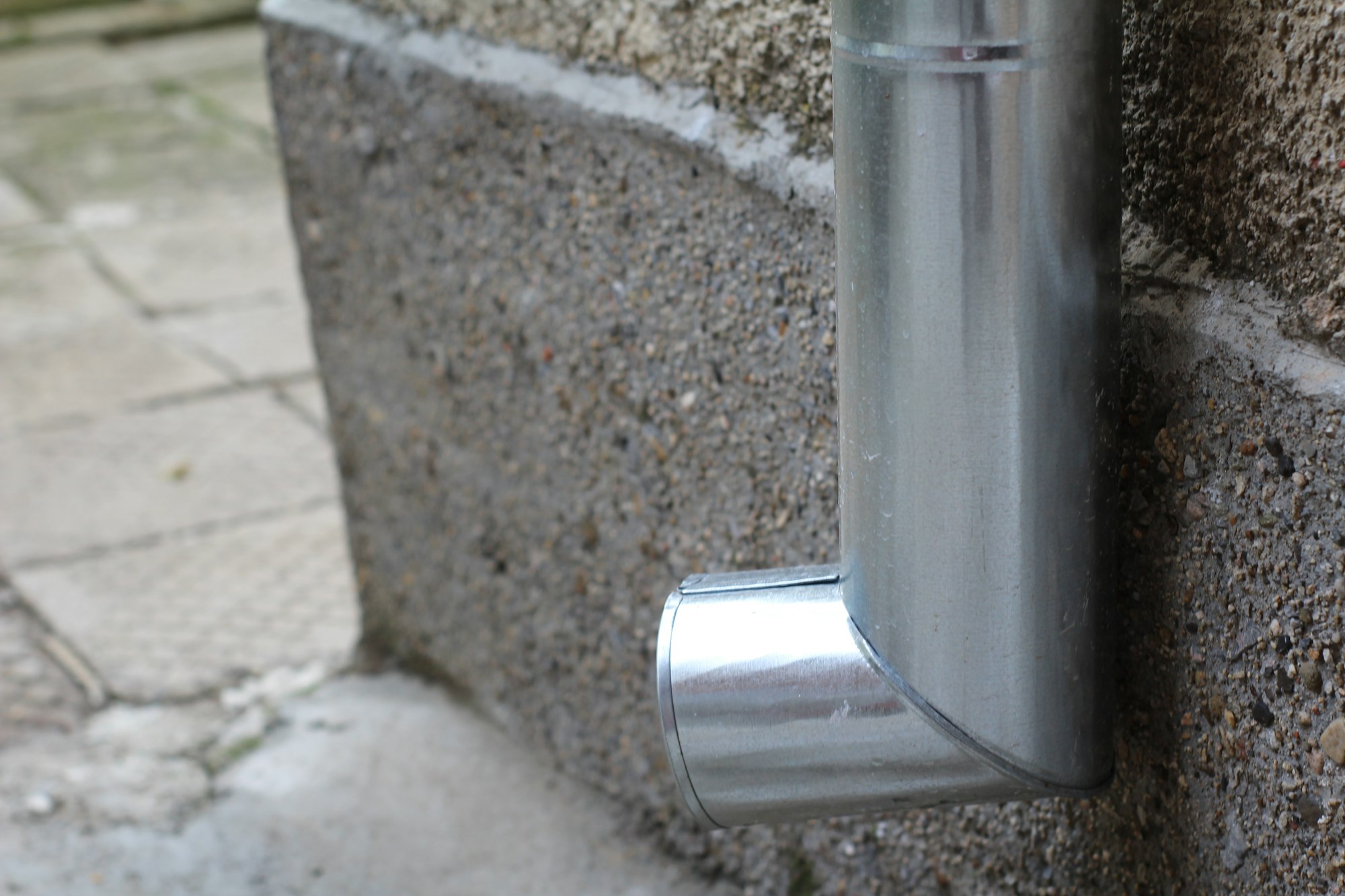 Metal gutter downspout on a wall